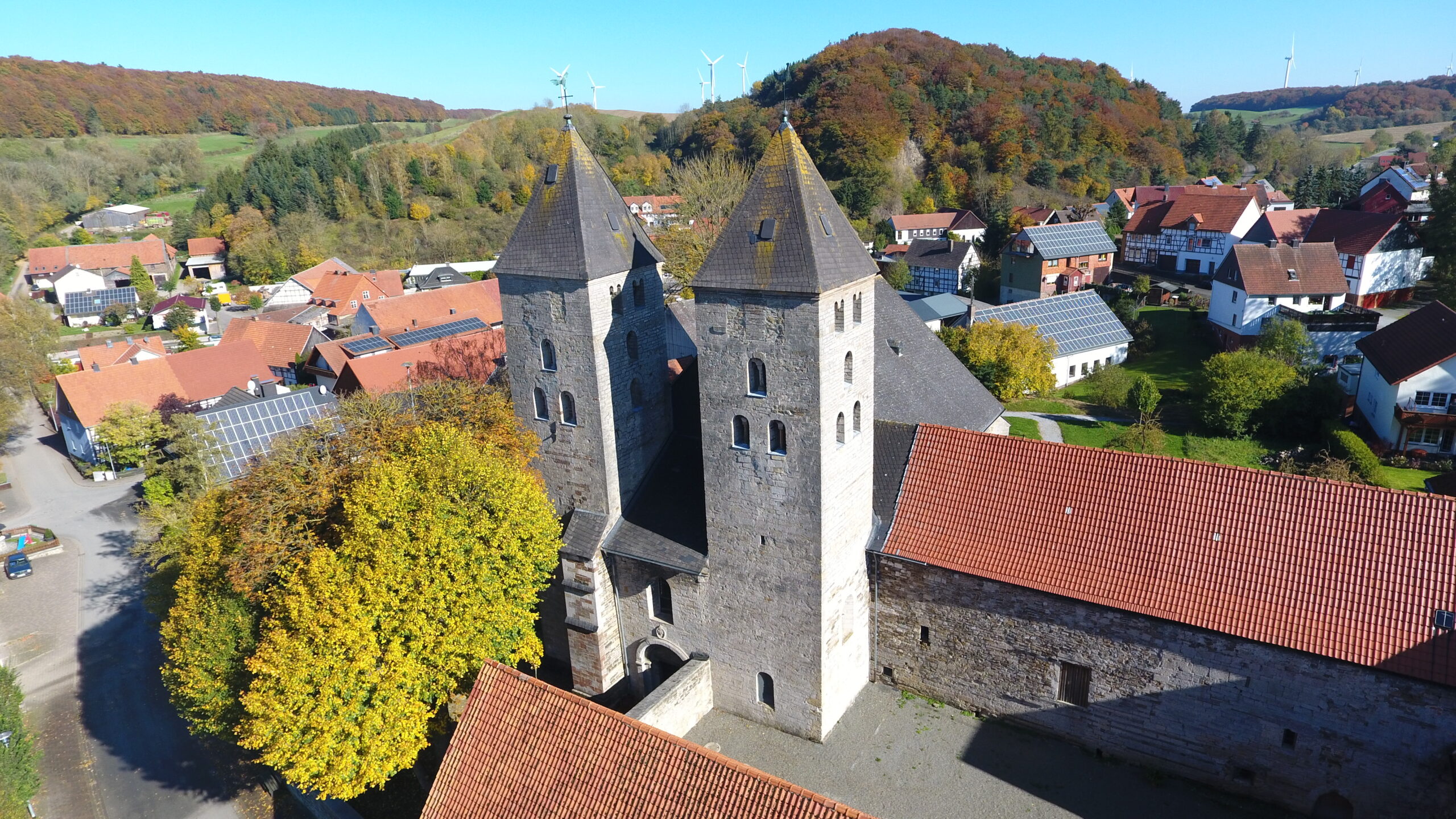 Die Klosterkirche Flechtdorf von oben. Im Hintergrund einige Häuser von Flechtdorf. Umgeben von einem herbstliche Wald. Die Klosterkirche Flechtdorf von oben. Im Hintergrund einige Häuser von Flechtdorf. Umgeben von einem herbstliche Wald.